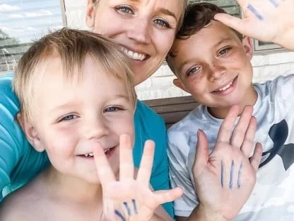 A mother and her two sons, marks drawn on their palms