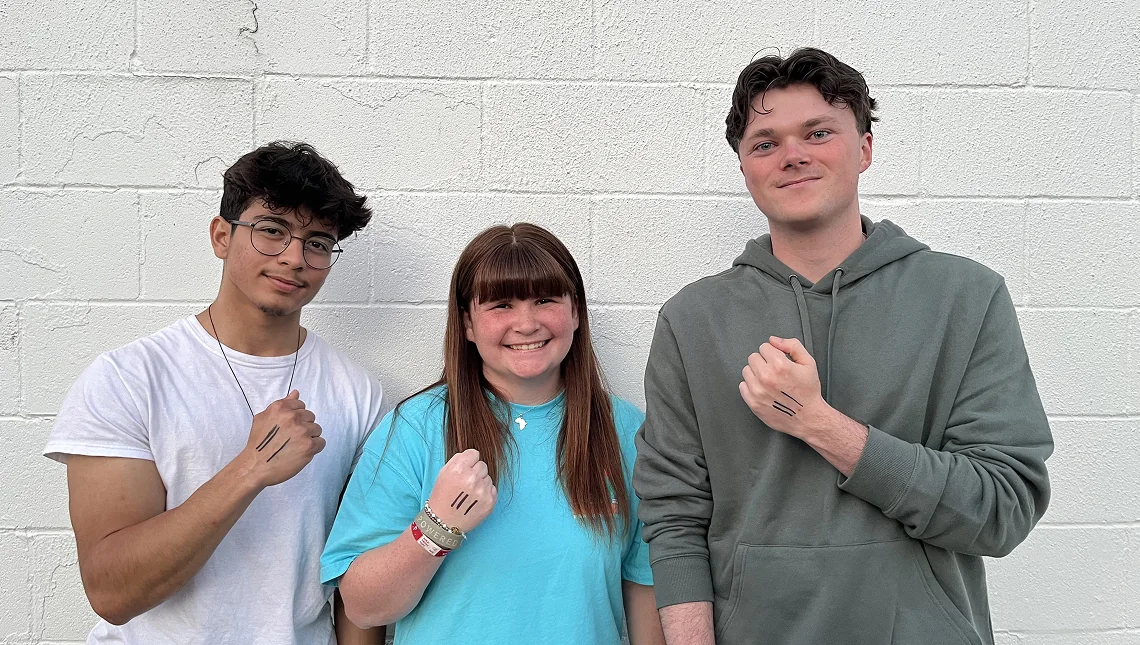 Three young people holding up hands marked with the A Third of Us line