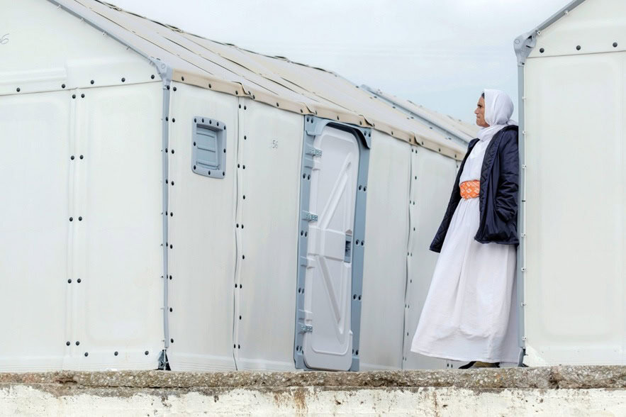 Woman in modest attire standing outside a medical tent for healing missions.