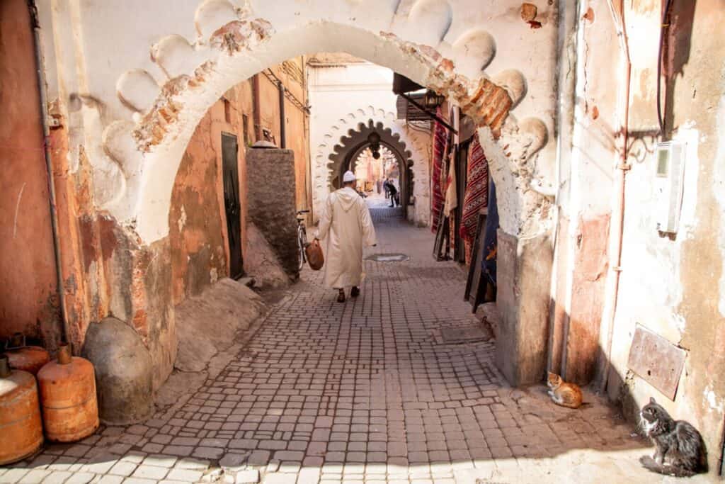 Traditional Moroccan street scene with archway and local vendor.