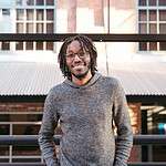 Young man smiling outdoors, promoting youth discipleship and mission training.