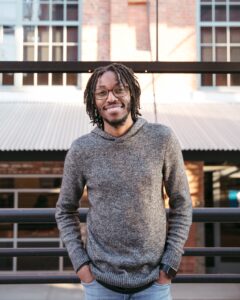 Young man smiling outdoors, promoting youth discipleship and mission training.