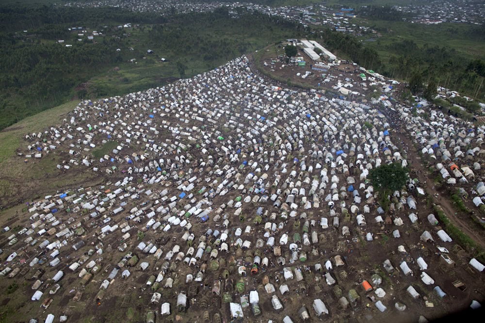 Aerial view of a large refugee camp with numerous tents and shelters.