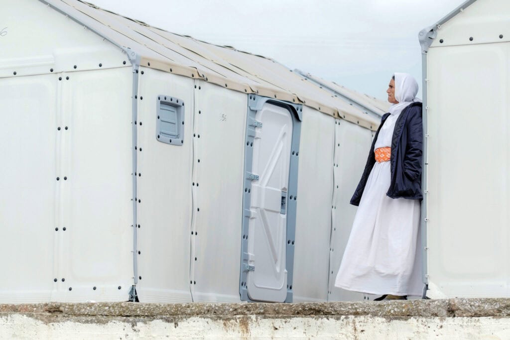 Woman in traditional dress visiting a mission tent at Missio Nexus event.