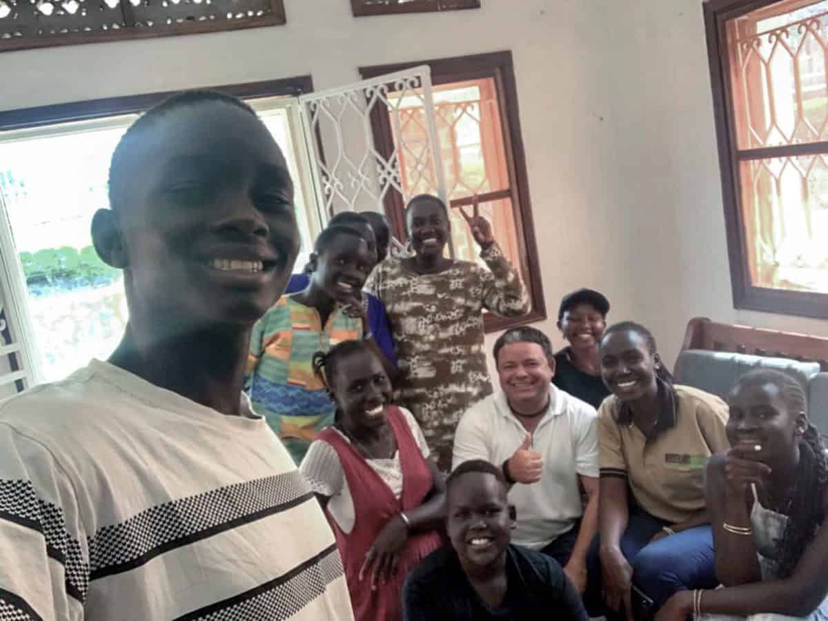 Group of diverse people smiling indoors, celebrating together.