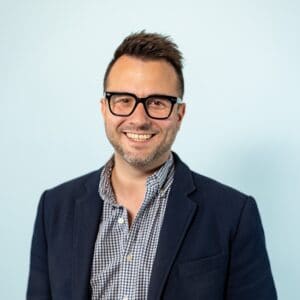 Professional man in business attire smiling, representing healthy mission agency leadership.
