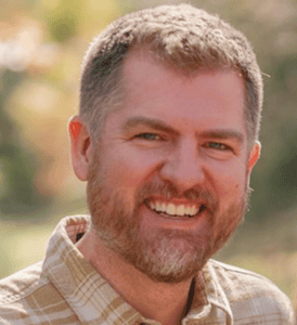 Smiling man outdoors at Missio Nexus event, autumn background.