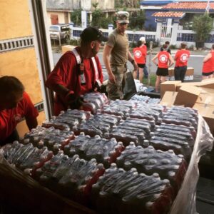 Volunteers distributing bottled water and supplies at a community outreach event.
