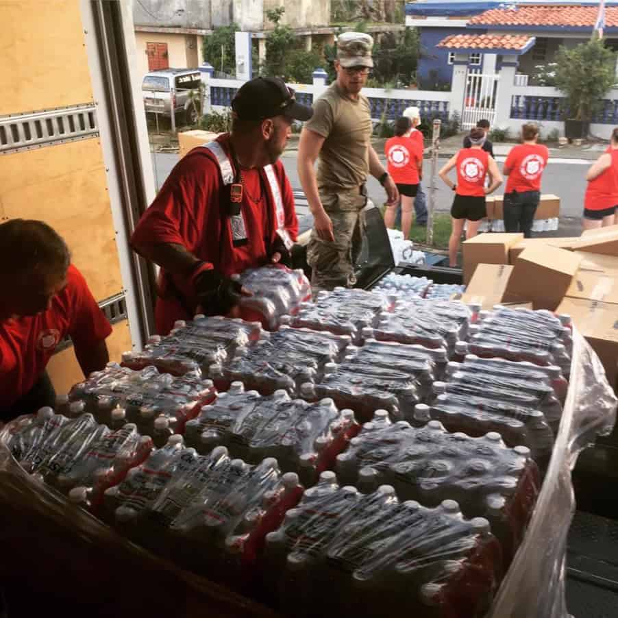 Volunteers distributing bottled water and supplies at a community outreach event.