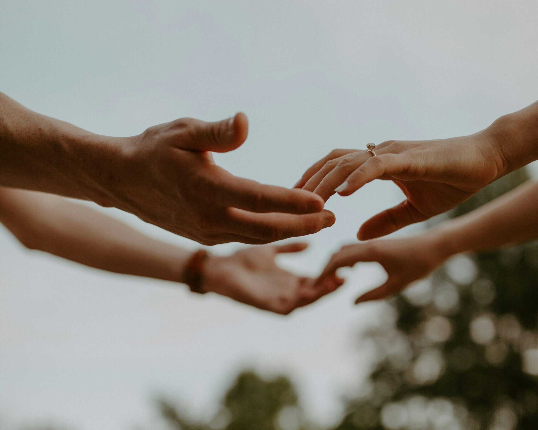Hands reaching out to build trust among cross-cultural workers.