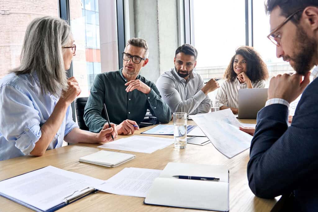 Business professionals engaged in a discussion at a conference table.