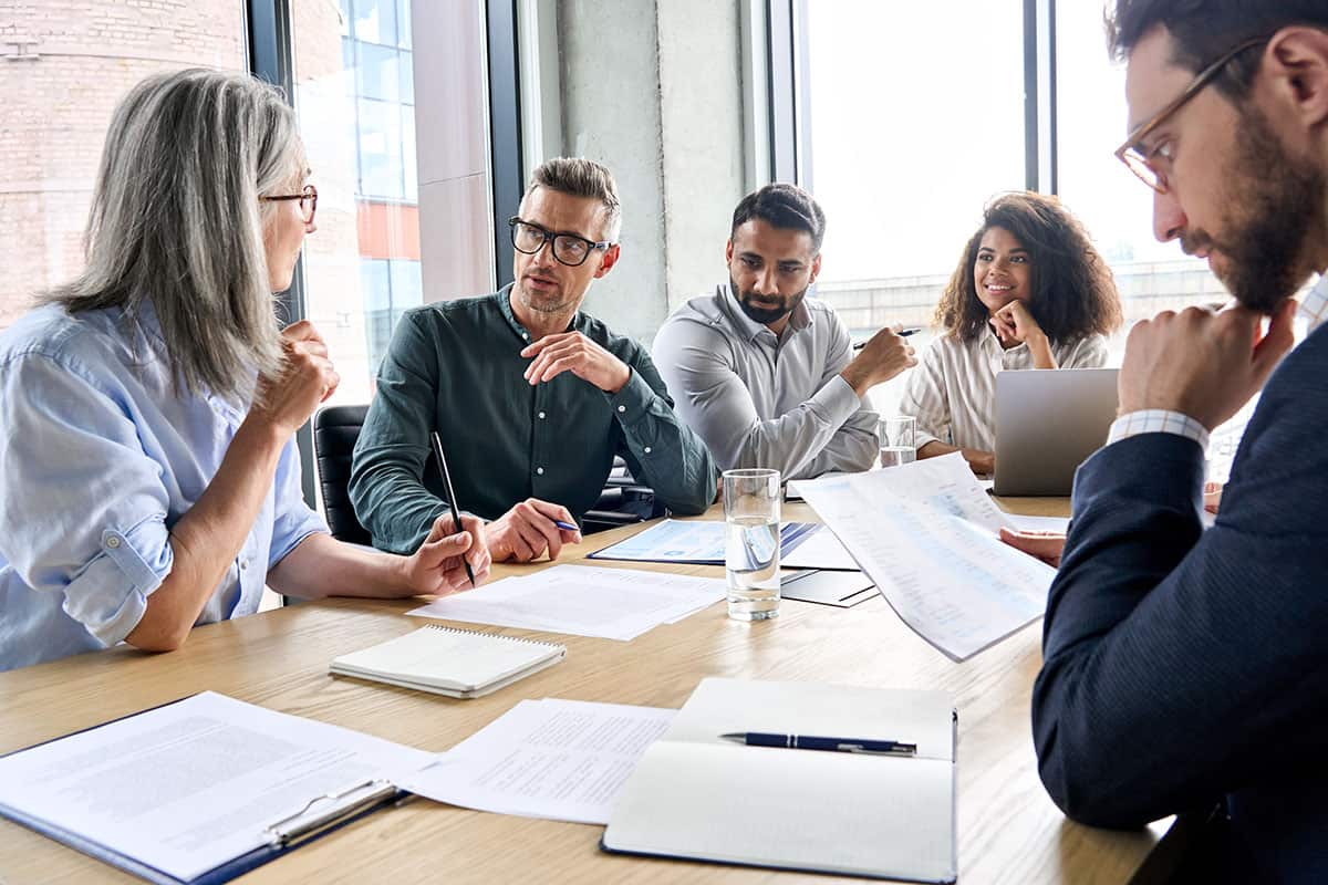 Business professionals engaged in a discussion at a conference table.