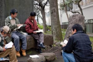 People reading and studying outdoors in a park setting.