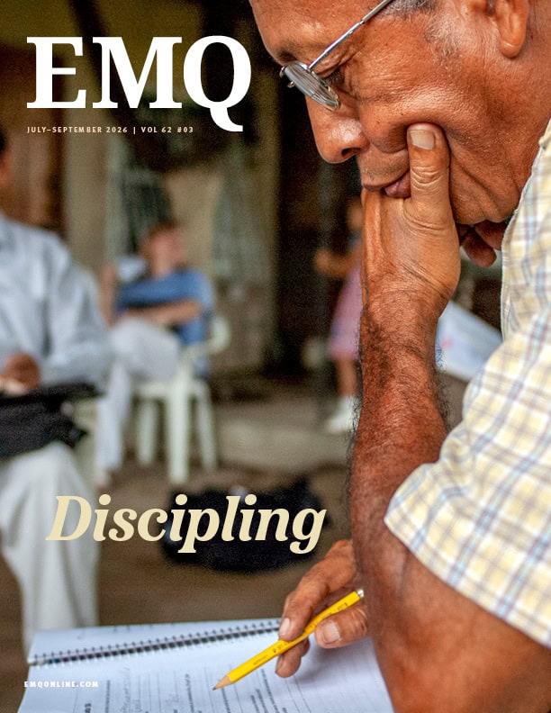 Elderly man studying notes with a thoughtful expression at a community gathering.