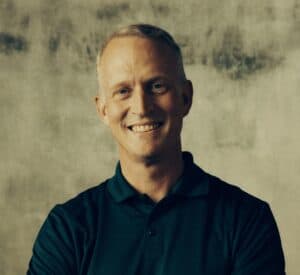 Smiling man in navy polo shirt at Missio Nexus event.